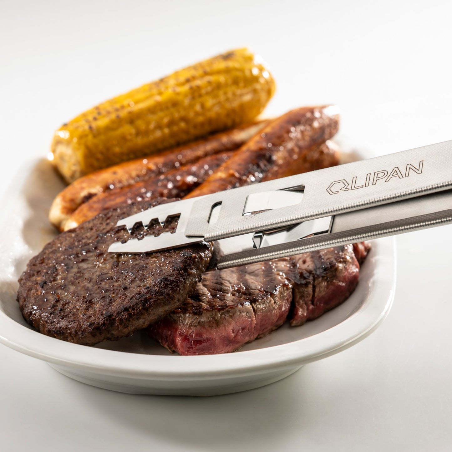 QLIPAN Grillzange mit Shark Qlip beim Einsatz am Grill