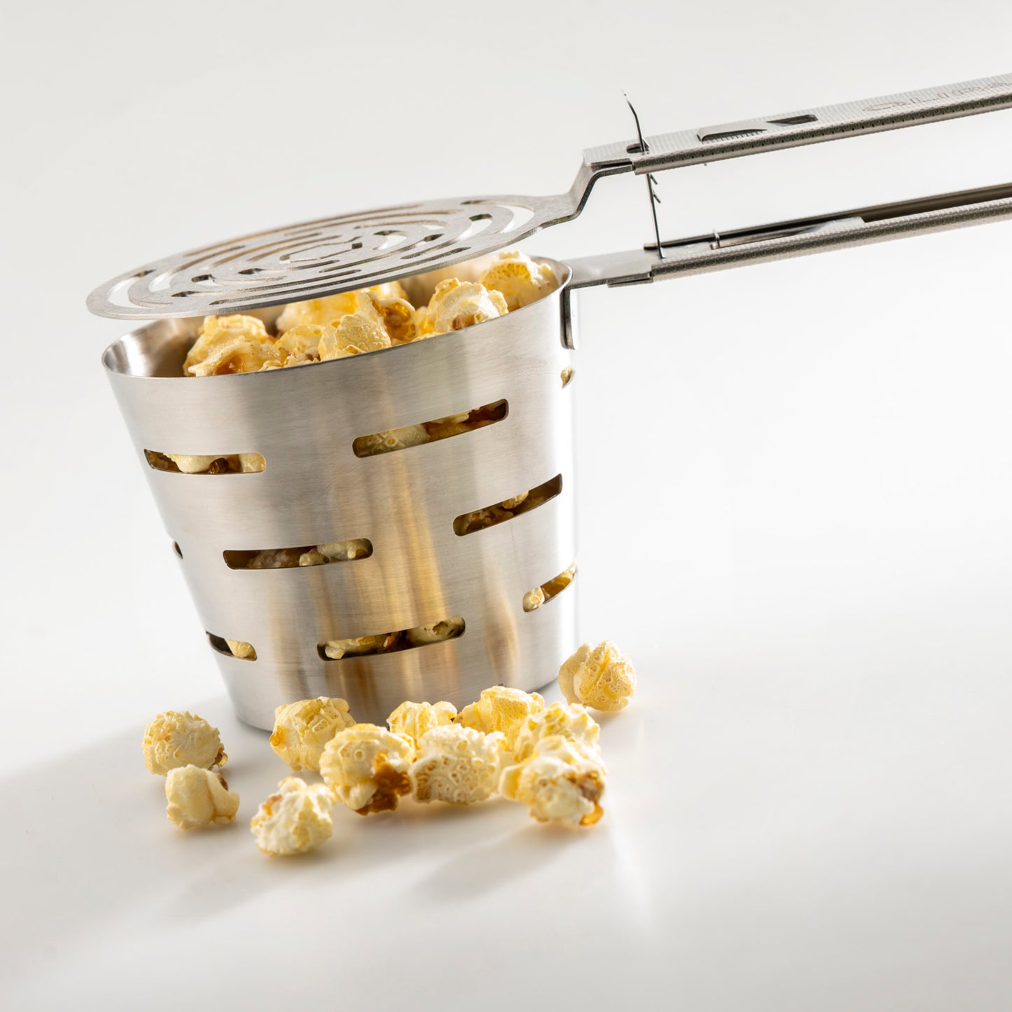 QLIPAN Popper Qlip beim Zubereiten von Popcorn über der Glut